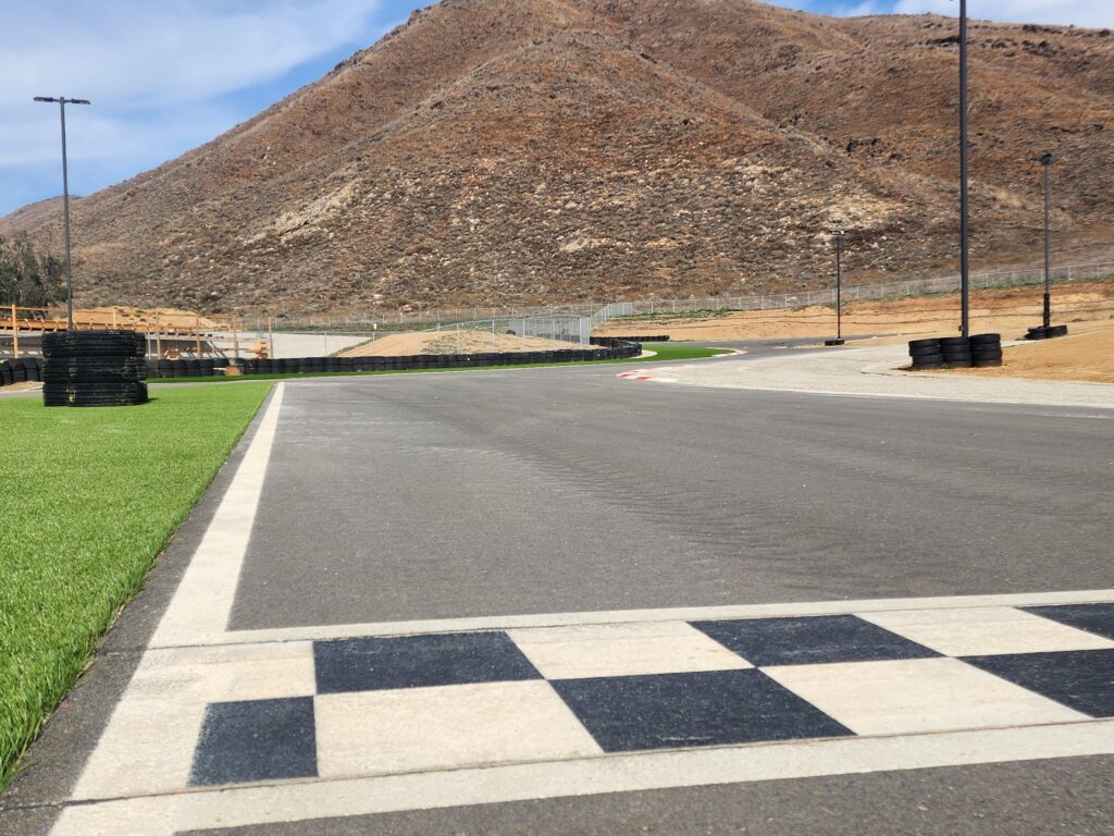 the start/finish line at k1 circuit featuring bright green turf trackside
