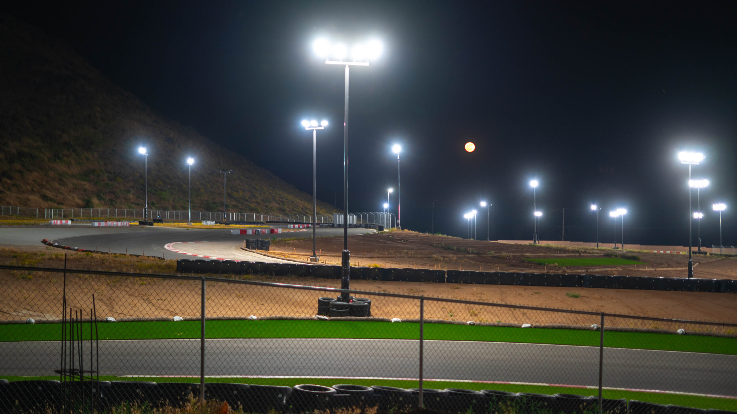 the moon rises in the background in this night shot of k1 circuit