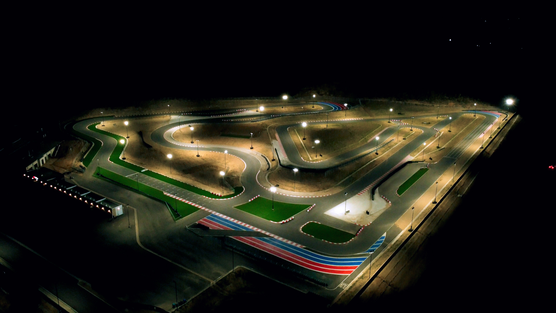 an aerial picture of k1 circuit at night with track lights bathing the circuit in light