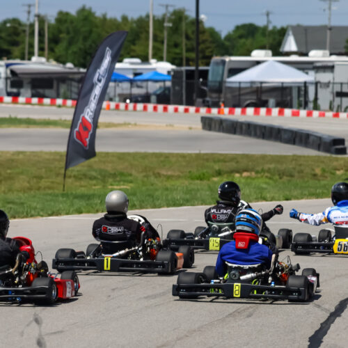 karts race at k1 circuit whiteland with two drivers fist-bumping each other out front