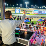 A DJ plays music from the podium balcony at K1 Circuit